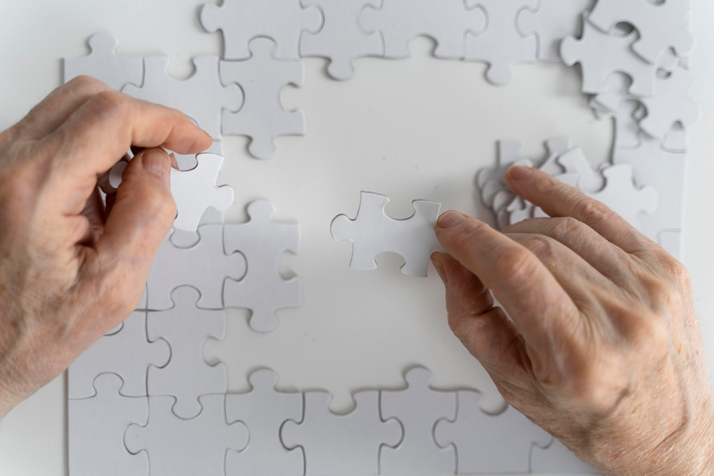 Picture of a man doing a puzzle. Aging With Grace